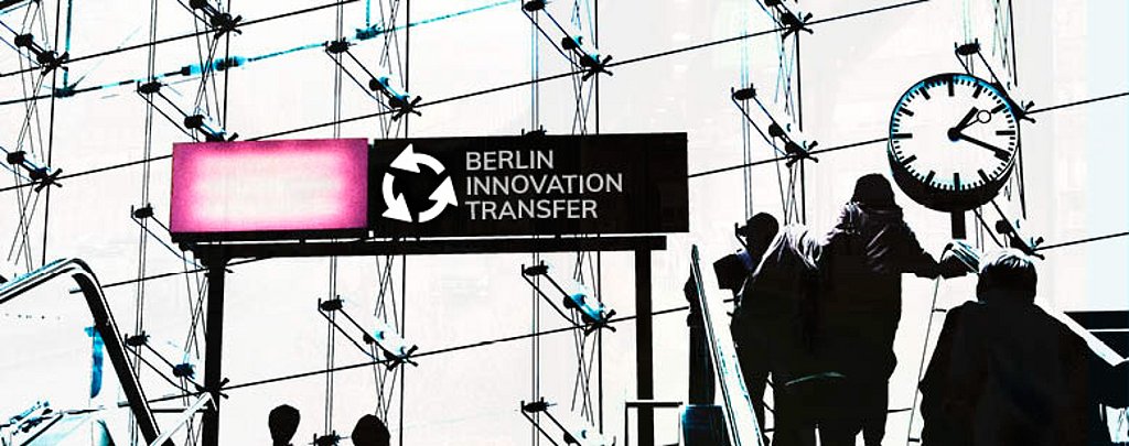 Menschen auf einer Rolltreppe über denen ein Banner mit der Aufschrift "Berlin Innovation Transfer" steht.
