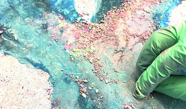 Gesiebtes Kreidepulver wird auf eine gestaltete Leinwand (mit Kreidespray) gebracht