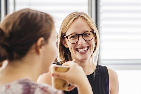 Gespräch zwischen zwei Kommilitoninnen des Master of Arts Studiengangs Intercultural Conflict Management Studierende lacht in die Kamera