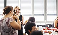 Gespräch zwischen zwei Kommilitoninnen des Master of Arts Studiengangs Intercultural Conflict Management Studierende lacht in die Kamera