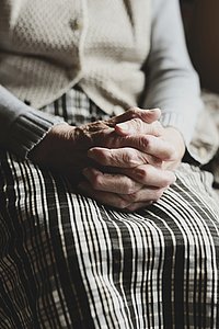 Fotoausschnitt alte Dame Alte Dame die ihre Hände auf ihrem Schos verschränkt