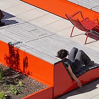 Auf dem Foto ist die Dachterasse der ASH Berlin zu sehen. Auf der Terasse sitzen zwei Studierende der ASH Berlin