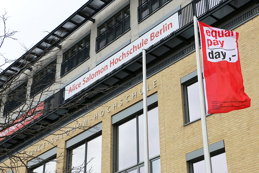 Die Equal-Pay-Day-Fahne weht vor dem Gebäude der ASH Berlin