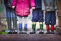 Kinderfüsse in Gummistiefeln