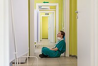 Erschöpfte Pflegende sitzend auf dem Krankenhausflur