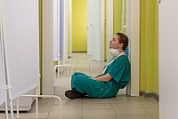 Erschöpfte Pflegende sitzend auf dem Krankenhausflur