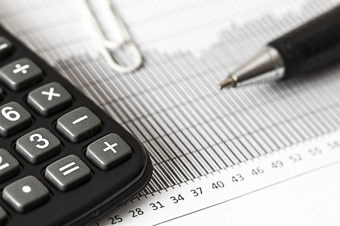 Calculator Taschenrechner und Kugelschreiber auf Statistikblatt - Controlling