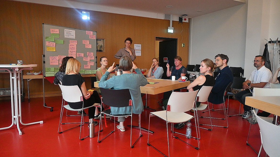 Teilnehmende der interaktiven Informationsveranstaltung zum Integrierten Qualitätsmanagement diskutieren an Thementischen Facetten und Handlungsfelder von Qualitätsentwicklung.
