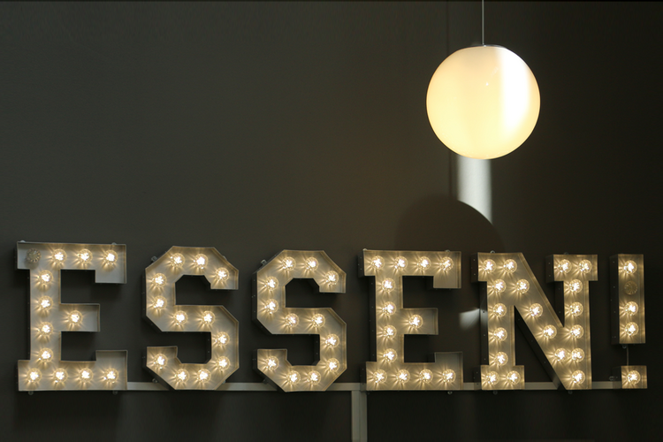Die Lampe der Mensa lässt Die Buchstaben des Wortes "Essen" erleuchten.
