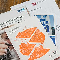 Blick von oben auf verschiedene Broschüren von Drittmittelgebern, darunter das IFAF Berlin, lesbar sind die Titel "Forschung an Fachhochschulen" und "Mit der Praxis forschen"