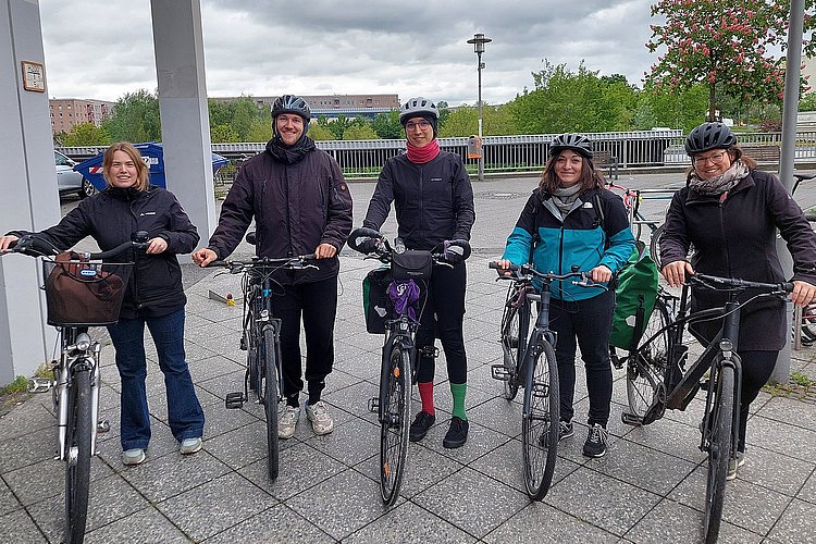 Foto von fünf Fahrradfahrenden vor dem Hauptgebäude der ASH Berlin