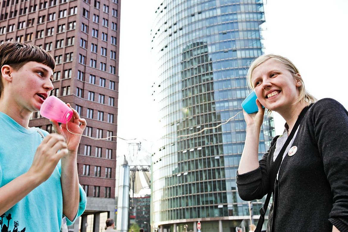 Zwei Personen mit Dosentelefon am Potsdamer Platz