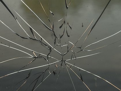 Zerbrochenes Fensterglas als Ausdruck häuslicher Gewalt während Corona